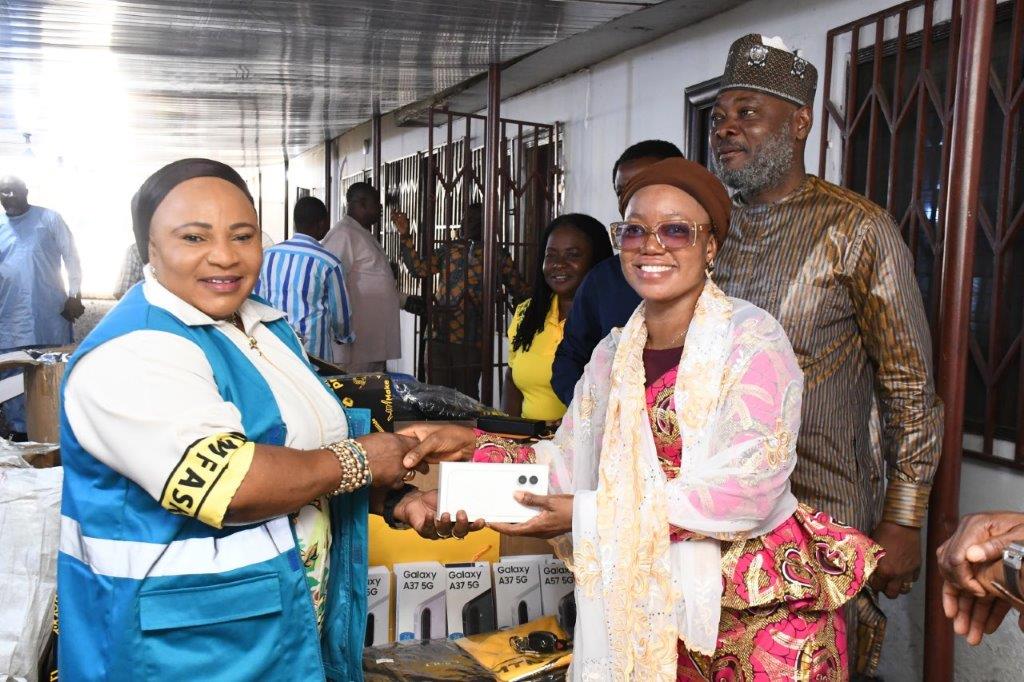 Muniratu Iddi-Abass Hussein (L), Controller, Lite Retail Experience at MTN Ghana presenting the device to a member of the...